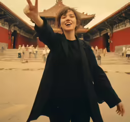 the woman is making a peace sign outside