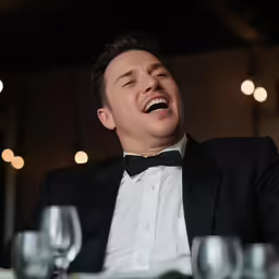 a man in a tuxedo is enjoying a meal