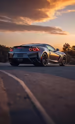 the grey and black sports car is driving on the road