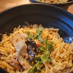 a bowl is full of pasta, meat and sauce