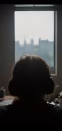 the woman is looking out of a window in front of a desk