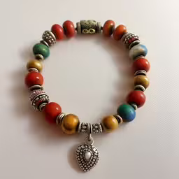 the beads with the heart and two charms are colorful,a multi colored bracelet has an antique charm
