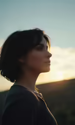 a woman with black hair standing against the sun