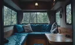 the inside of an rv with a large blue couch and windows