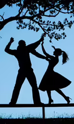 a couple is dancing on a bench under the tree