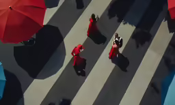 several women in long red dresses are walking down the street