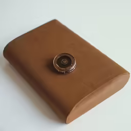 a brown paper bag on the table with a button on it