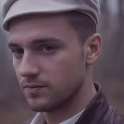 a man in a leather jacket and cap