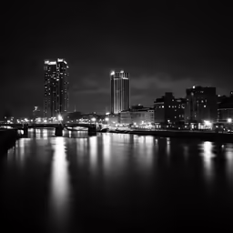 a city view at night with lights reflecting on water