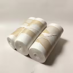 three rolls of white toilet paper sitting on top of each other