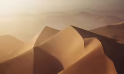 sand dunes in the desert, with mountains in the background