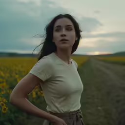 a beautiful young woman standing in a sunflower field