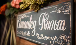 a wooden sign with flowers displayed in the corner