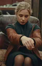 a woman sitting in an old chair touching her finger