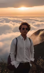 a man in a white shirt wearing sunglasses while standing with his hands in his pockets