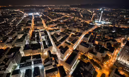 an aerial view shows the city streets lit up at night