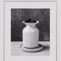 a white vase sitting on top of a table