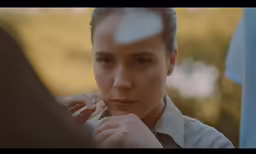 a woman looks at the camera in a blurry photo