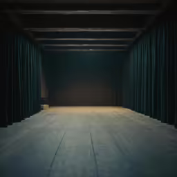 an empty stage with green curtains in the center