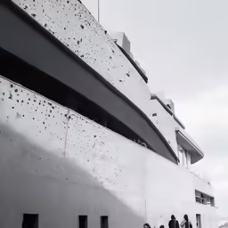 people walking past the facade of an architecture building