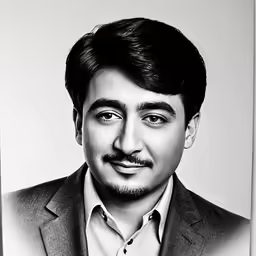 a man in a suit looks at the camera with smile