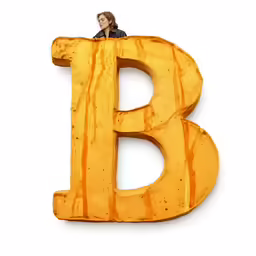 the letter b made of wood with a woman on top