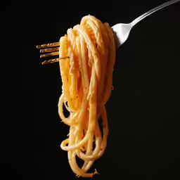 spaghetti being held from fork with black background