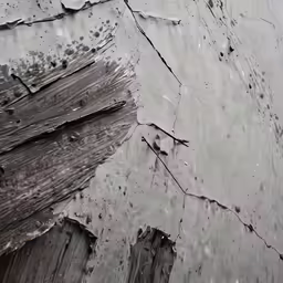 a wood building with mud on it and cracks in the wall