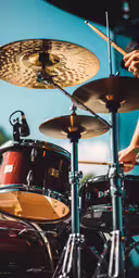 the drummer is playing drums in the music,a close up of the drums in front of two men