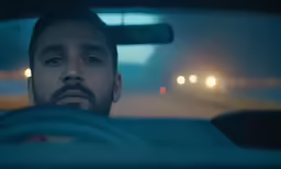 a man sitting in a car at night