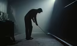 a man cleaning the floor in a foggy room