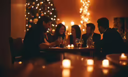 people are sitting around a table with wine glasses