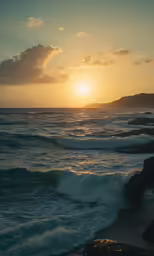 the sun is setting over the ocean as it waves