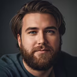 man with beard wearing blue and grey shirt