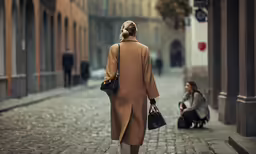 woman in long coat sitting on a brick walk, on foot, next to woman with handbag