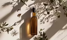 an olive oil bottle surrounded by small leaves