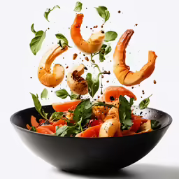 a black bowl is filled with food and some meat