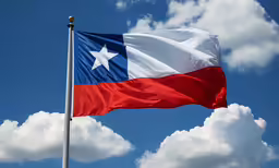 a flag flying in the air with clouds below