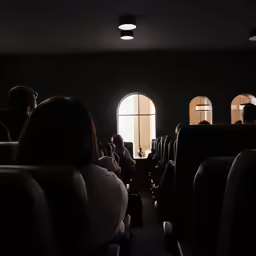 people sit in seats and watch on an empty airplane