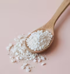 there is a small wooden spoon full of white substance