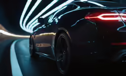 a black car driving down a road at night
