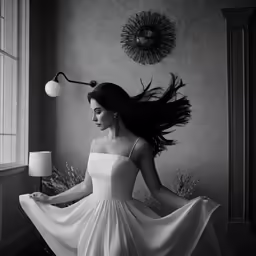 a woman in a long white dress holding a lamp