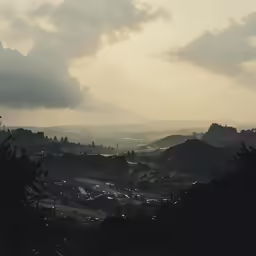 the sun is shining through the cloudy skies over a hill