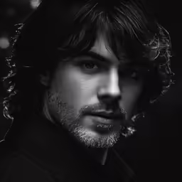 a man in black shirt looking away from the camera