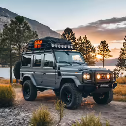 there is a silver land rover that is in the sunset