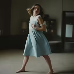 a girl in a dress is dancing in the room