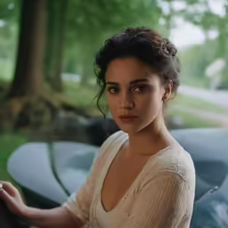 a woman holding a piece of car windshield in her hand