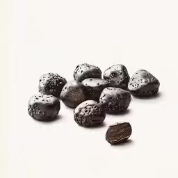 one single piece of chocolate sits in the middle of chocolate pieces