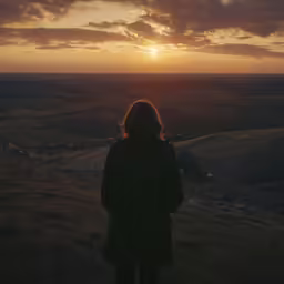 there is a woman that is standing alone in the evening