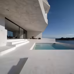 a long, white swimming pool near a modern building